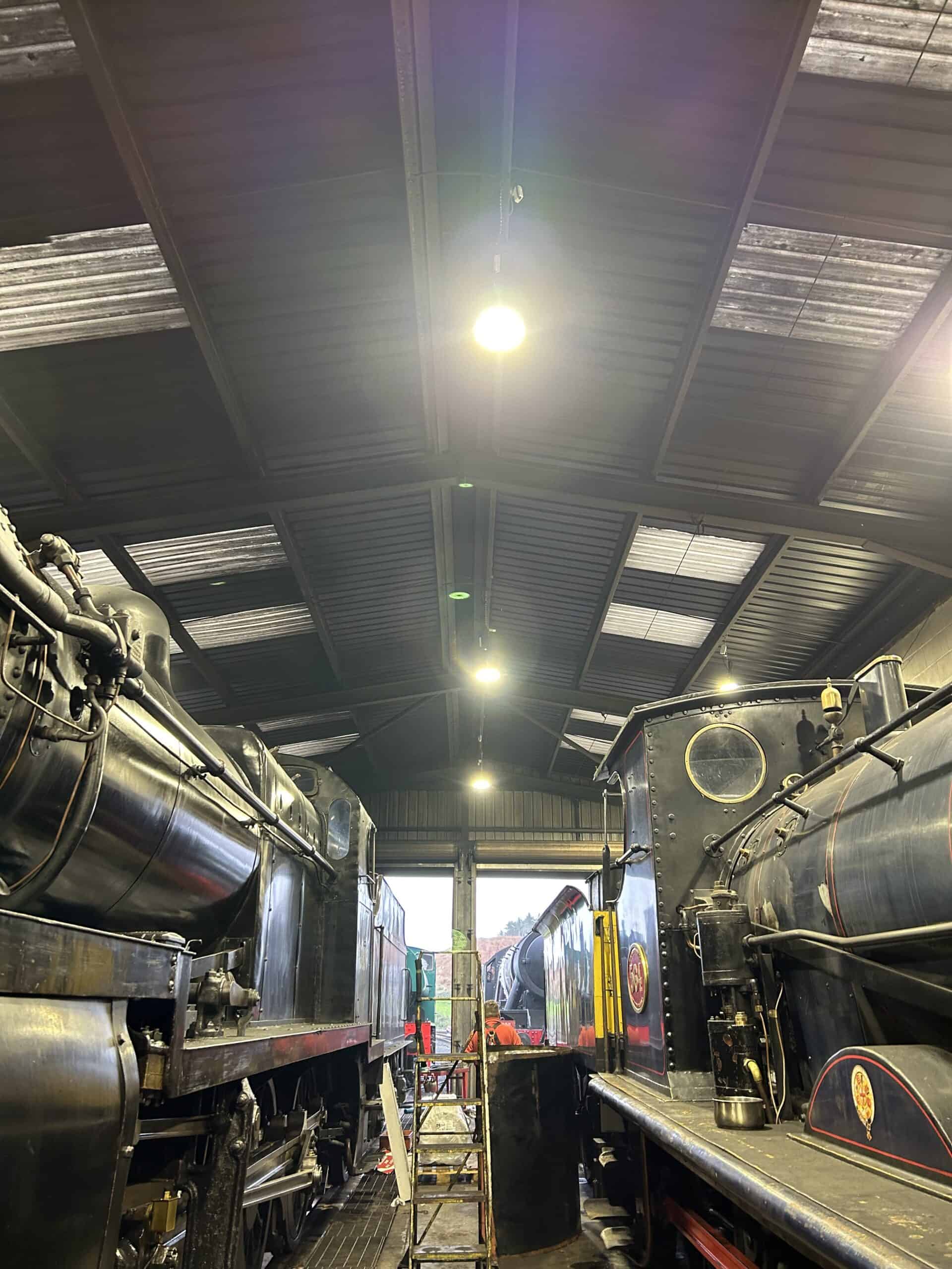 Interior of a train workshop with steam locomotives.